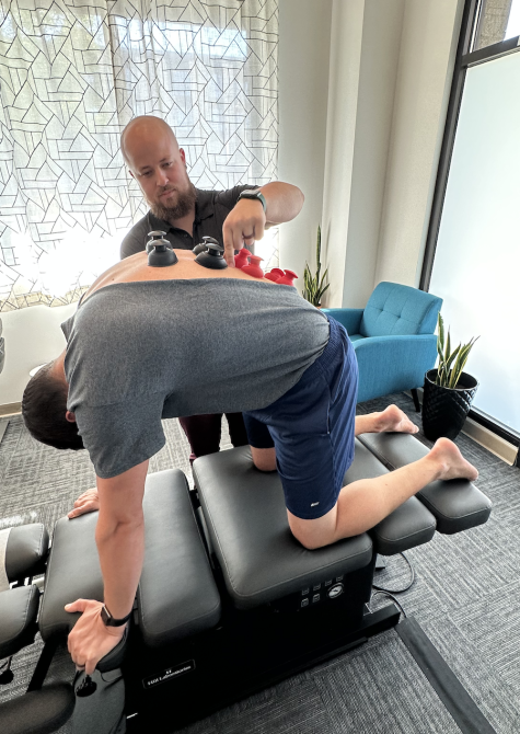 Sports Chiropractor in Bellingham performing manual therapy or body work by relaxing postural muscles in a patients spine